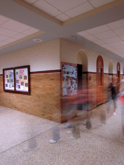 A group of kids moving in a school hallway.