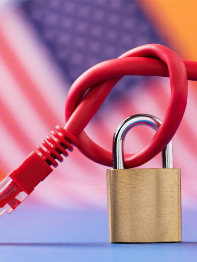 Closed padlock on a knotted network wire on the background of the American flag.