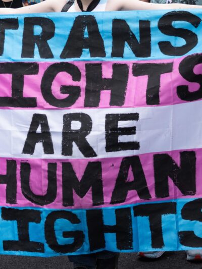 Trans Rights, speakers, protesters, and supporters denounce the Trump Administration's persistent attacks on the transgender community. by carrying a huge sign reading" TRANS RIGHTS ARE HUMAN RIGHTS".