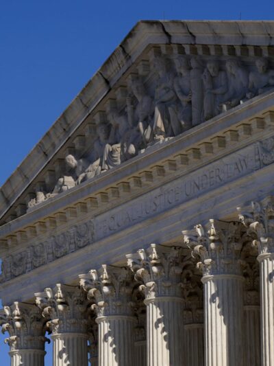 A half-lowered US flag waves in front of the US Supreme Court.
