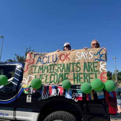People holding a banner on the back of a truck.