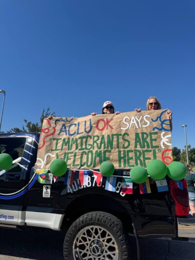 People holding a banner on the back of a truck.
