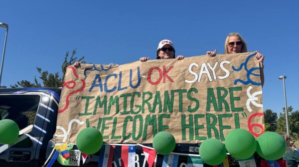 People holding a banner on the back of a truck.