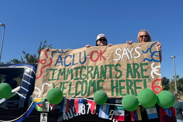 People holding a banner on the back of a truck.