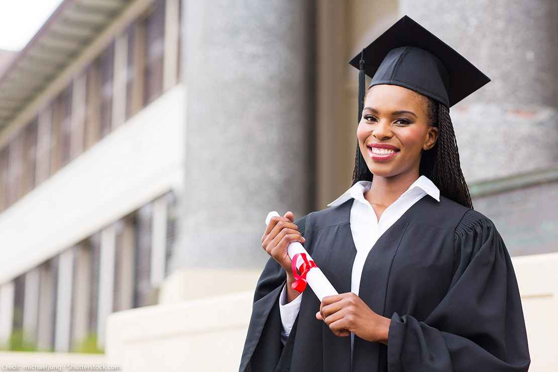 Black woman in cap and gown holds a diploma