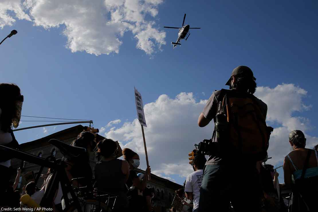 Protestors react to a low flying helicopter during a march in Brooklyn, New York.