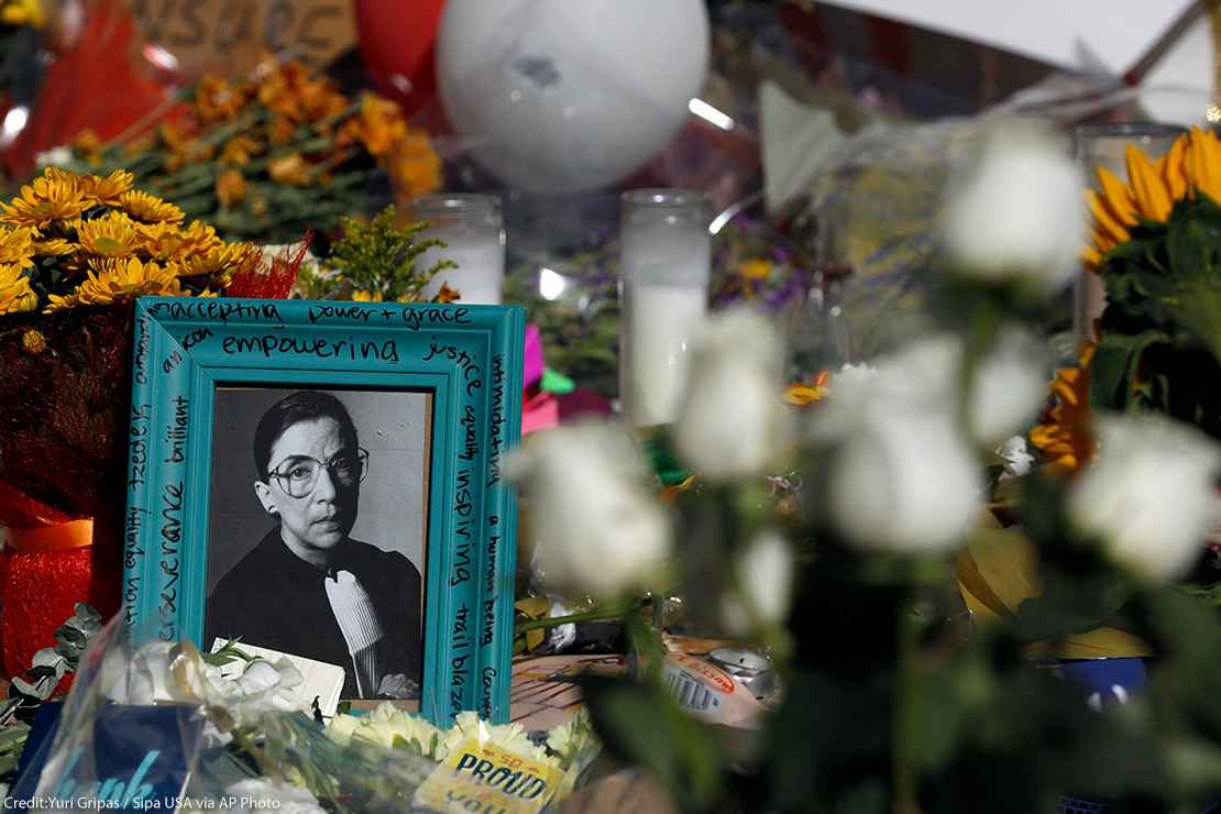 Flowers and a poster with an image of late Associate Justice Ruth Bader Ginsburg are placed outside the Supreme Court in Washington, DC