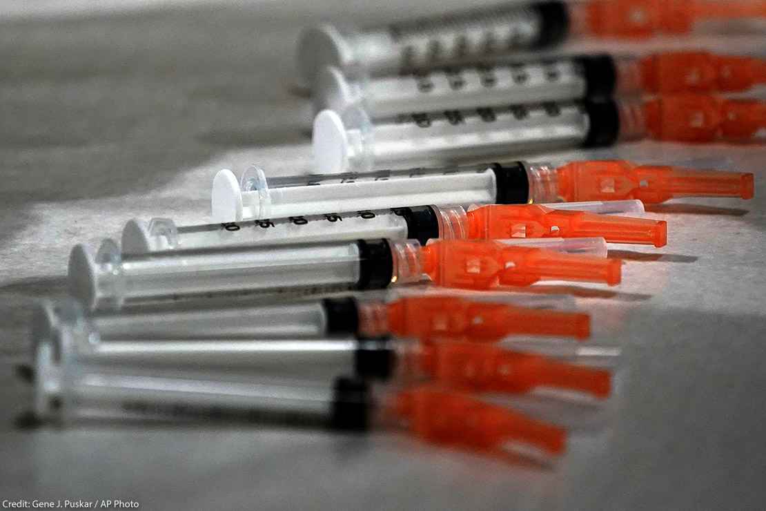 Syringes loaded with the Moderna COVID-19 Vaccine spread on a clinic table