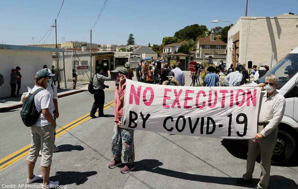 A sign reading "No Executions by Covid-19" is seen at a protest