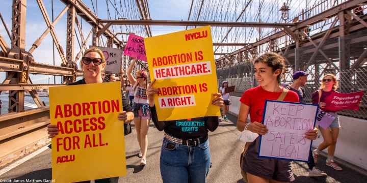 Three demonstrators holding pro-abortion signage.