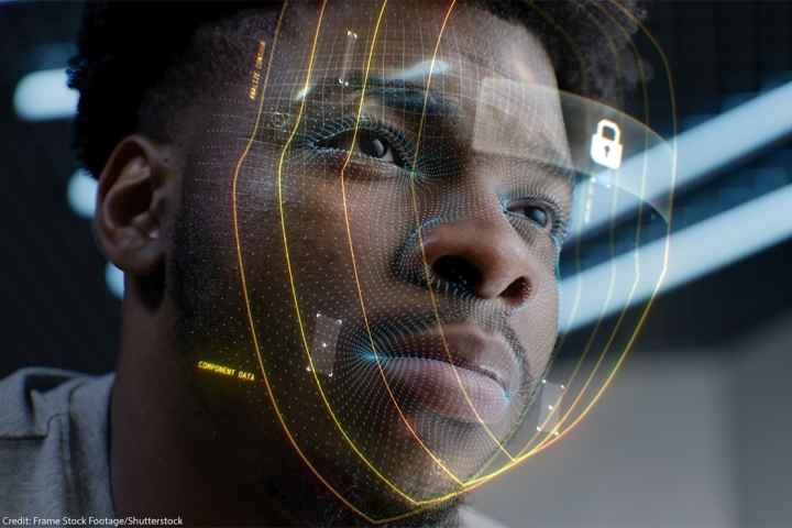 A closeup of a young African American man whose face is being scanned by facial recognition software.