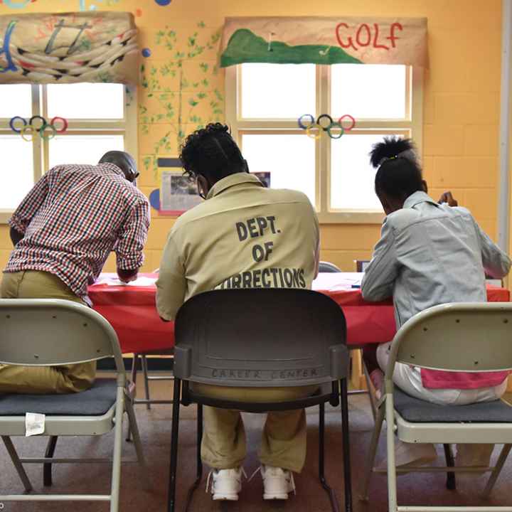 A woman held at the Pulanski State Prison in Georgia plays with her children in the prison's Children Center.