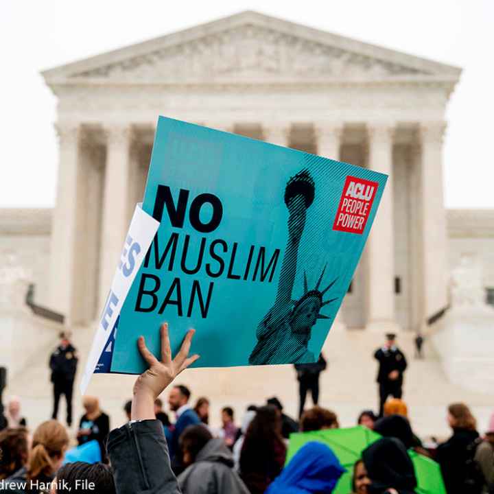 In this April 25, 2018 file photo, a person holds up a sign that reads "No Muslim Ban" during an anti-Muslim ban rally in front of the Supreme Court building in Washington, DC.
