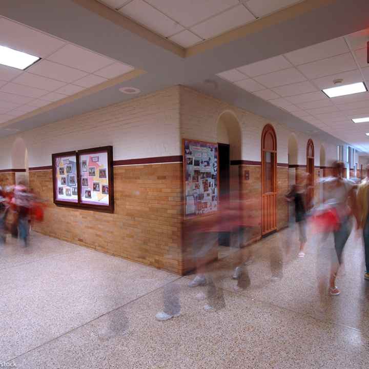 A group of kids moving in a school hallway.
